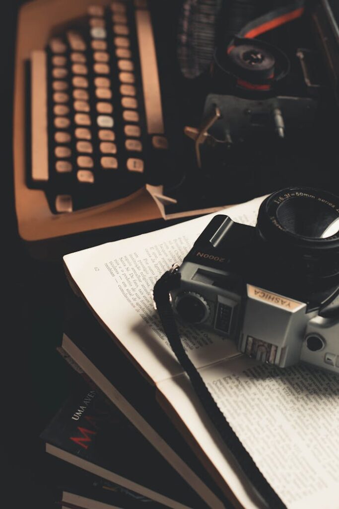 pexels-photo-3113527 Retro scene featuring a vintage camera and typewriter on an open book.